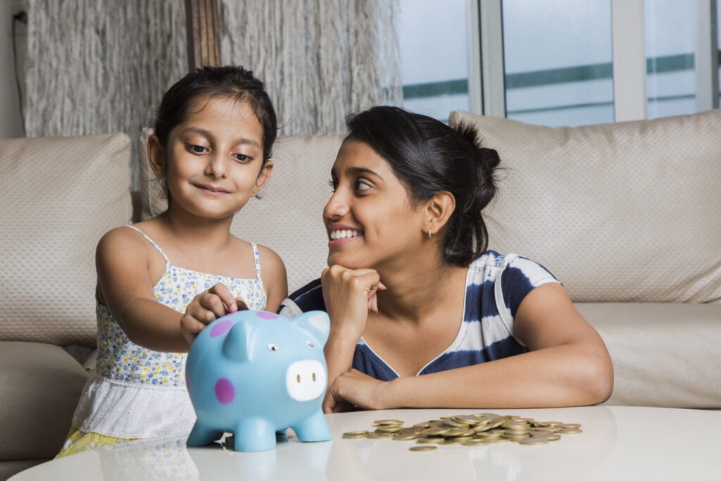 Mother and daughter with a piggy bank